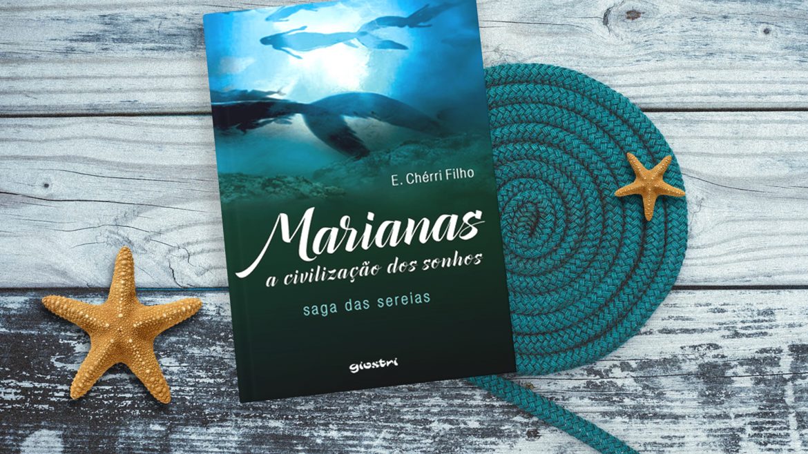 Marianas Livro "Marianas a Civilização dos sonhos" em cima de uma mesa de mandeira e duas estrelas do mar ao lado
