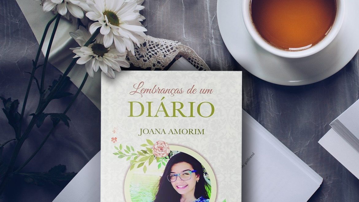 Livro "lembranças de um diário" em cima de uma mesa, flores brancas ao lado e uma caneca de chá