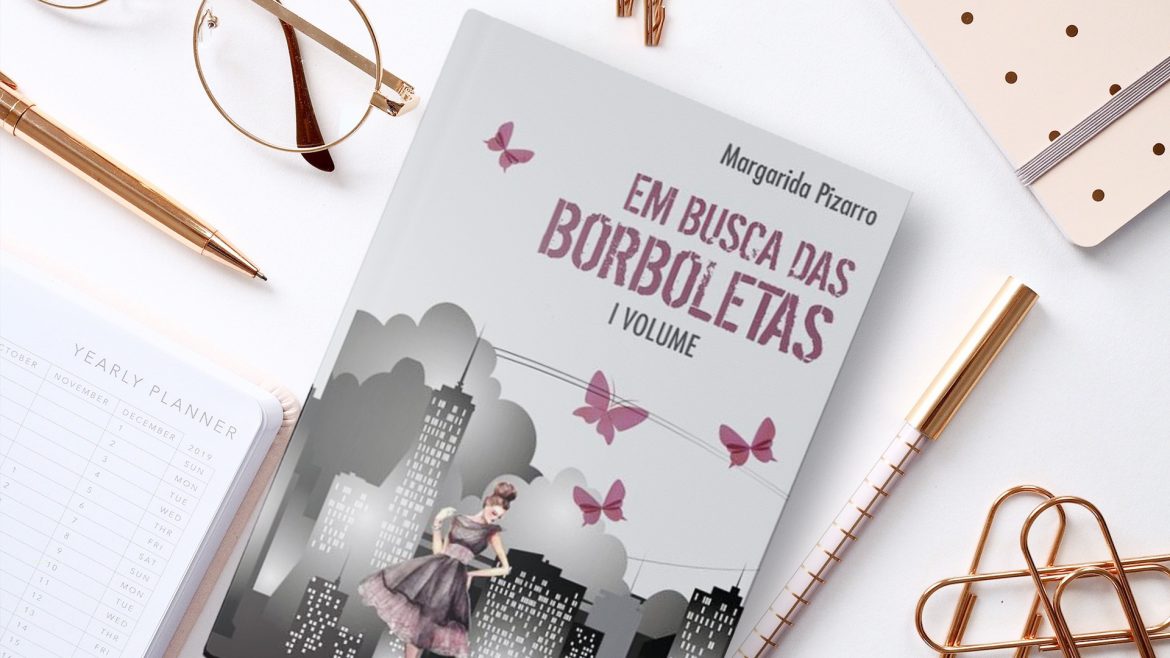 Em busca das borboletas Livro "Em busca das borboletas" no centro de uma mesa branca com itens de papelaria rosê
